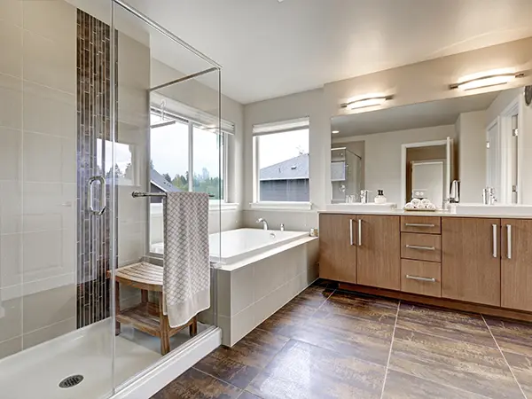 Modern bathroom remodel with glass shower, wood vanity, and elegant fixtures for a sleek aesthetic.