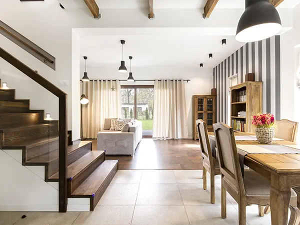 Elegant dining room with wooden staircase, open floor plan, and natural lighting for modern home design.