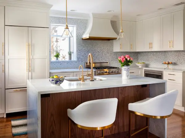 Luxurious kitchen with a white marble island, gold-accented fixtures, and custom cabinetry.